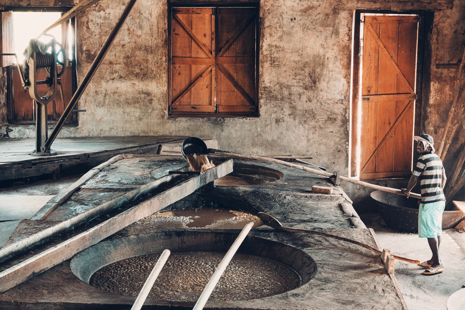 Worker at open fermentation vats in a rum distillery
